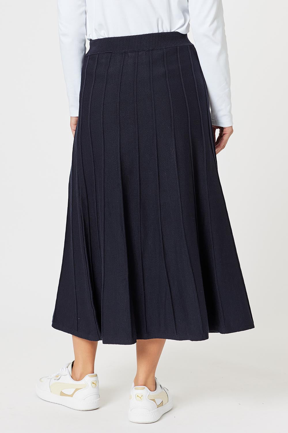 A model wearing the Kate Knit Long Skirt in colour Navy (Blue), from the back