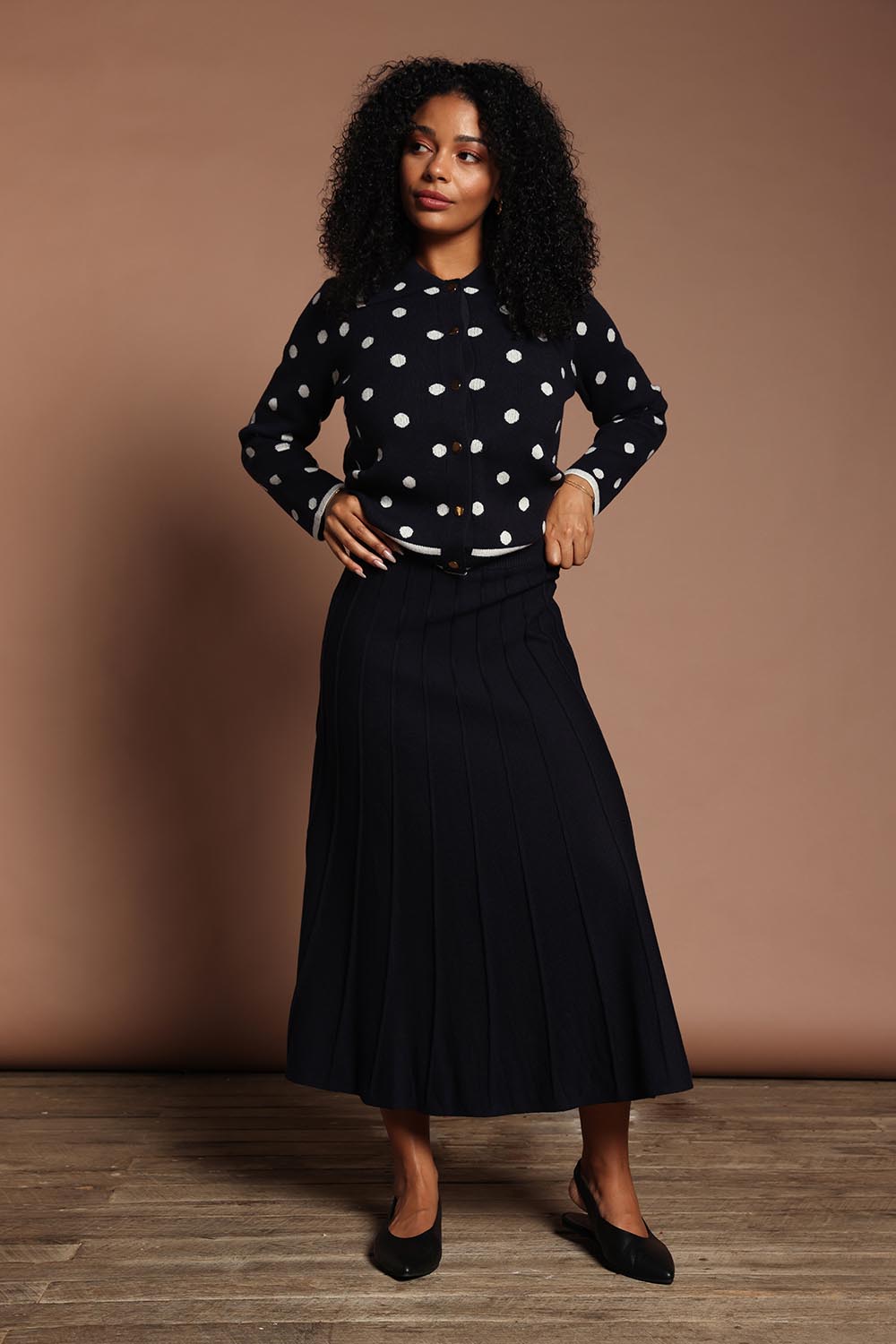 Model Ziara wearing size S of the Kate Knit Long Skirt in colour Navy (Blue), from the front, showing the whole outfit