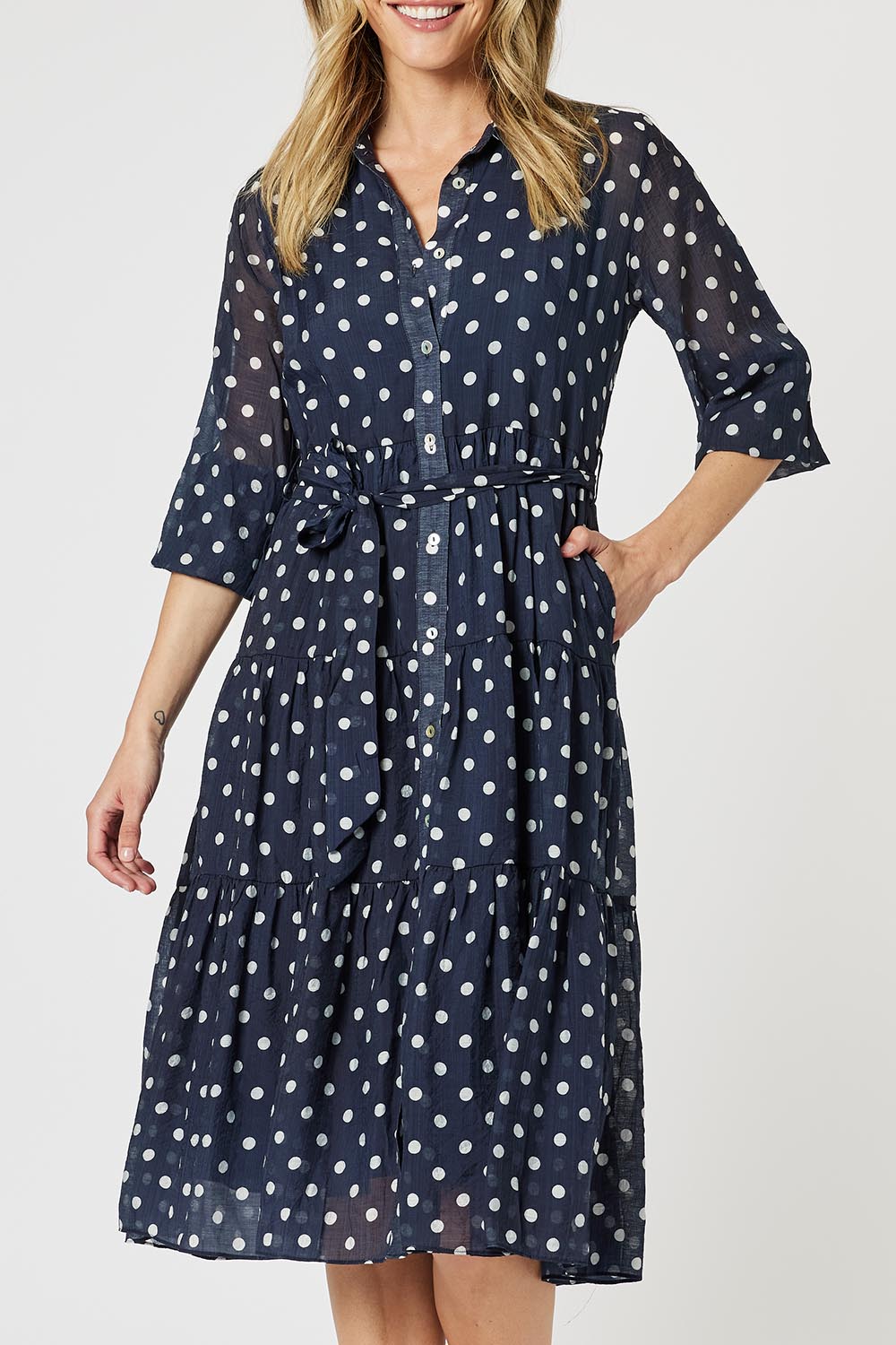 A model wearing the Sorrento Dress in colour Navy (Blue), from the front, cropped image