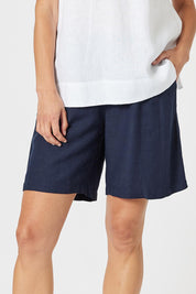 A model wearing the Lino Linen Blend Shorts in colour Navy (Blue), from the front, cropped image