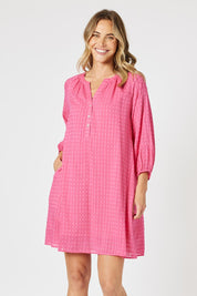 A model wearing the Mykonos Cotton Check Dress in colour Peony (Pink), from the front, cropped image