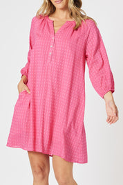 A model wearing the Mykonos Cotton Check Dress in colour Peony (Pink), from the front, cropped image