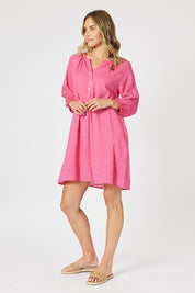 A model wearing the Mykonos Cotton Check Dress in colour Peony (Pink), from the front, showing the whole outfit