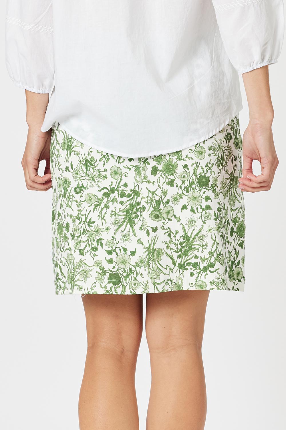 A model wearing the Alexandria Cotton Skirt in colour Basil (Green), from the back