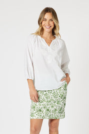A model wearing the Alexandria Cotton Skirt in colour Basil (Green), from the front, cropped image