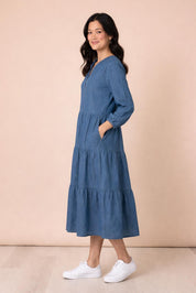 A model wearing the Macy Lyocell Dress in colour Denim (Blue), from the front, showing the whole outfit