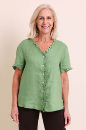 Model Sandys wearing size 10 of the Audrey Ruffle Linen Top - Fern in colour Fern, in a cropped view