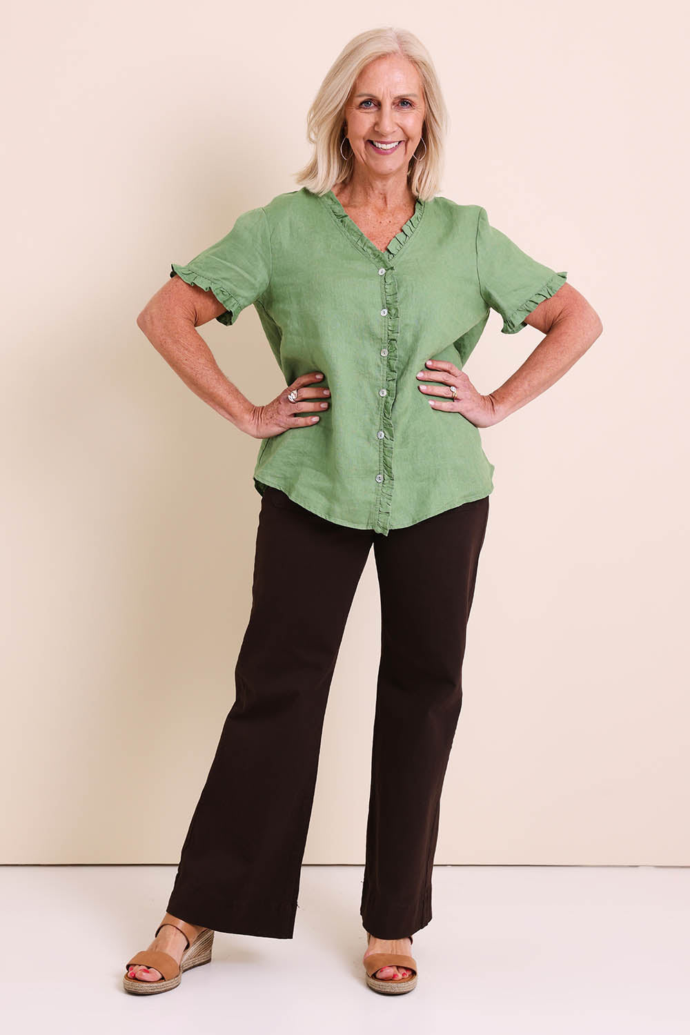 Model Sandys wearing size 10 of the Audrey Ruffle Linen Top - Fern in colour Fern, from the front