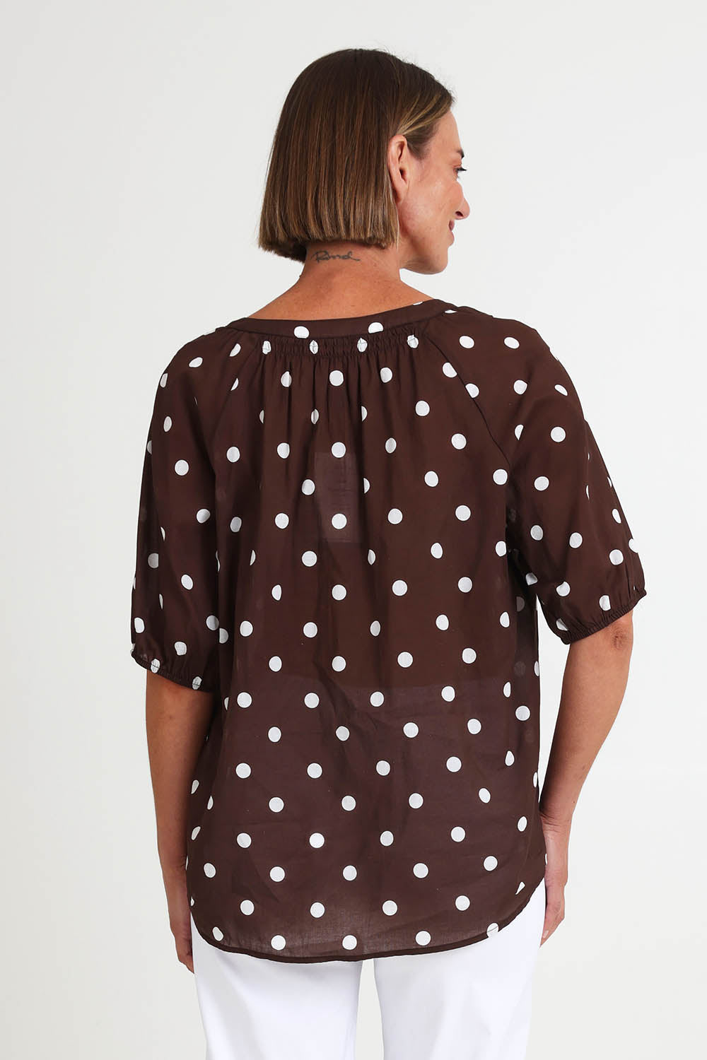 Model Riinar wearing size 10 of the Riviera Spot Top – Coffee in colour Coffee, from the back