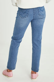 Model Emma wearing size 10 of the Slim Miracle Denim Jeans in colour Washdenim (Blue), from the back