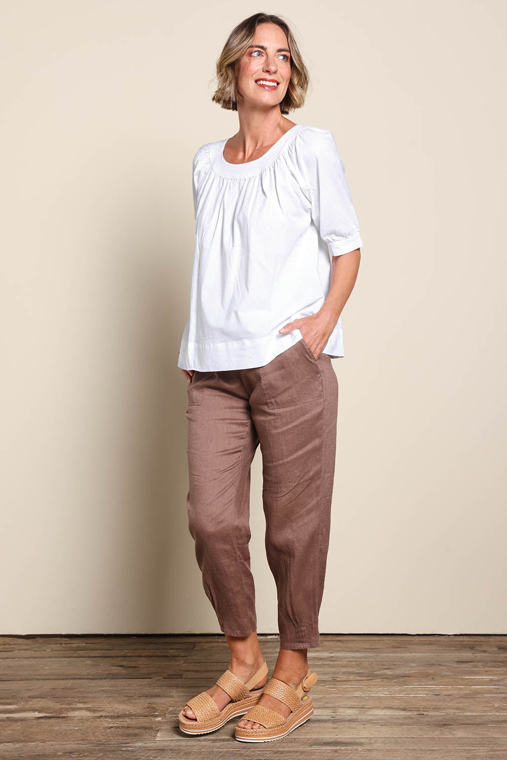 Model Riinar wearing size 10 of the Pull On Linen Pant - Mocha in colour Mocha, from the front