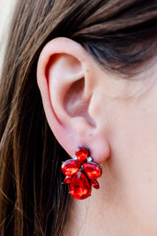 A model wearing the Small Bling Earrings in colour Red (Red), from the front, showing the whole outfit