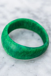 A model wearing the Resin Stacking Cuff Bangle in colour Green (Green), from the front, showing the whole outfit