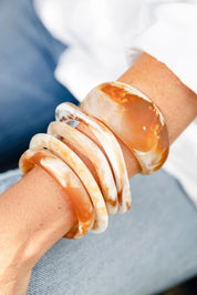 A model wearing the Resin Stacking Cuff Bangle in colour Horn, from the front, showing the whole outfit