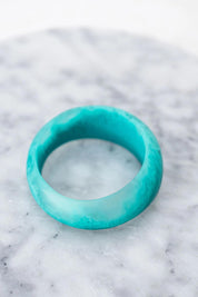A model wearing the Resin Stacking Cuff Bangle in colour Teal (Green), from the front, showing the whole outfit
