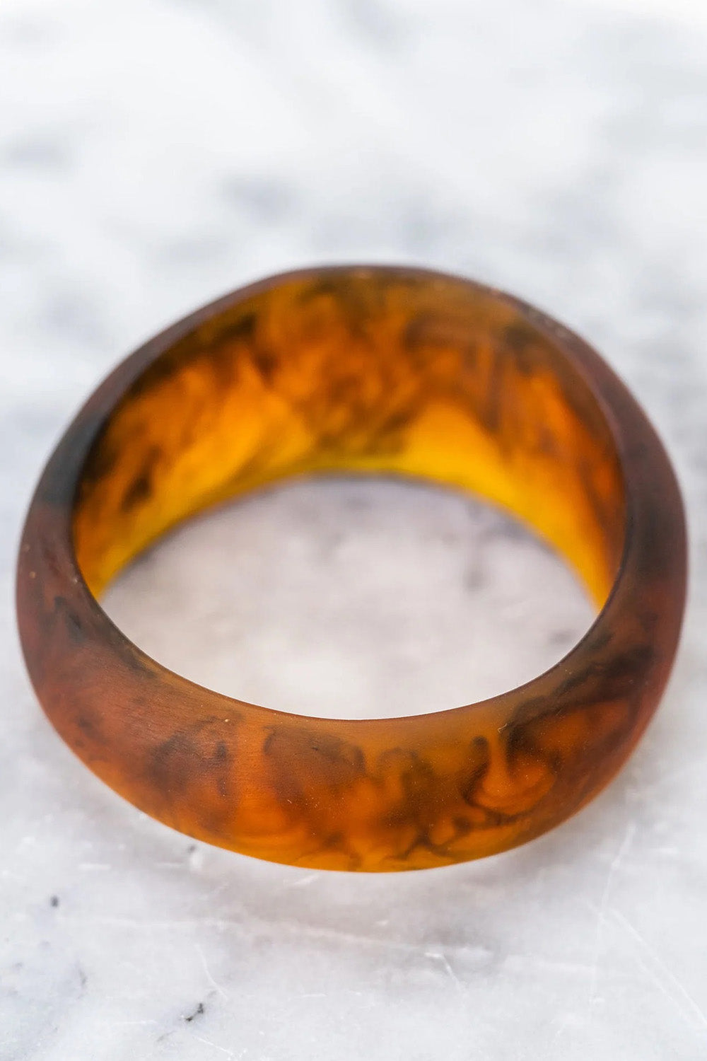 A model wearing the Resin Stacking Cuff Bangle in colour Tortoise, from the front, showing the whole outfit