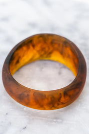 A model wearing the Resin Stacking Cuff Bangle in colour Tortoise, from the front, showing the whole outfit