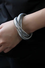 A model wearing the Flex Snake Chain Stretch Bracelet in colour Silver (Metallics), from the front, showing the whole outfit