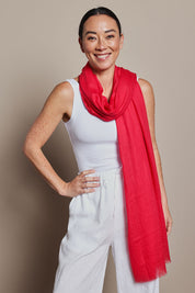 A model wearing the Solid Lightweight Scarf in colour Red (Red), from the front, showing the whole outfit