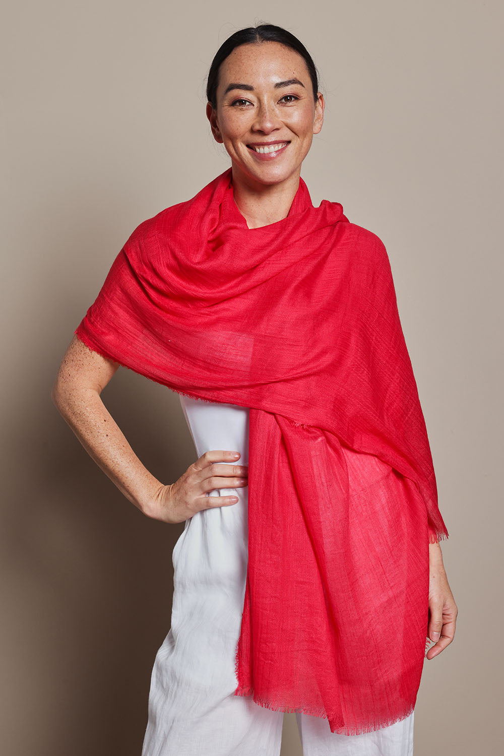 A model wearing the Solid Lightweight Scarf in colour Red (Red), from the front, showing the whole outfit