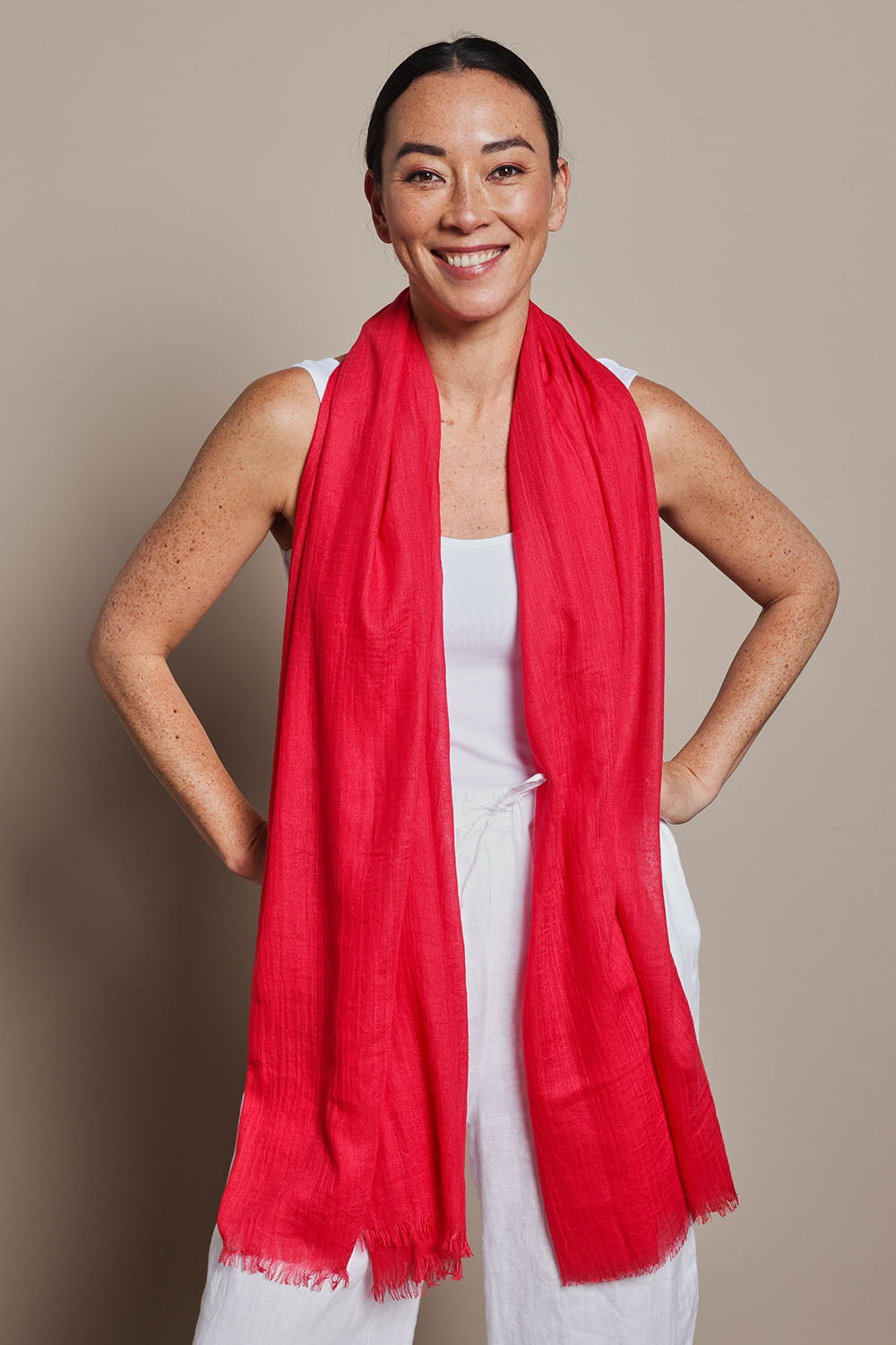 A model wearing the Solid Lightweight Scarf in colour Red (Red), from the front, showing the whole outfit