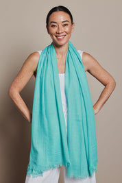 A model wearing the Solid Lightweight Scarf in colour Seafoam (Green), from the front, showing the whole outfit