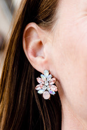 A model wearing the Medium Bling Earrings in colour Champagne (Pink), from the front, cropped image