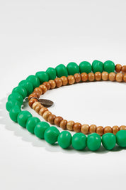 A model wearing size OneSize of the Mini Wood & Rock Necklace in colour Emerald (Green), from the front, showing the whole outfit