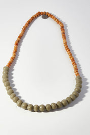 A model wearing size OneSize of the Mini Wood & Rock Necklace in colour Moss (Green), from the front, showing the whole outfit