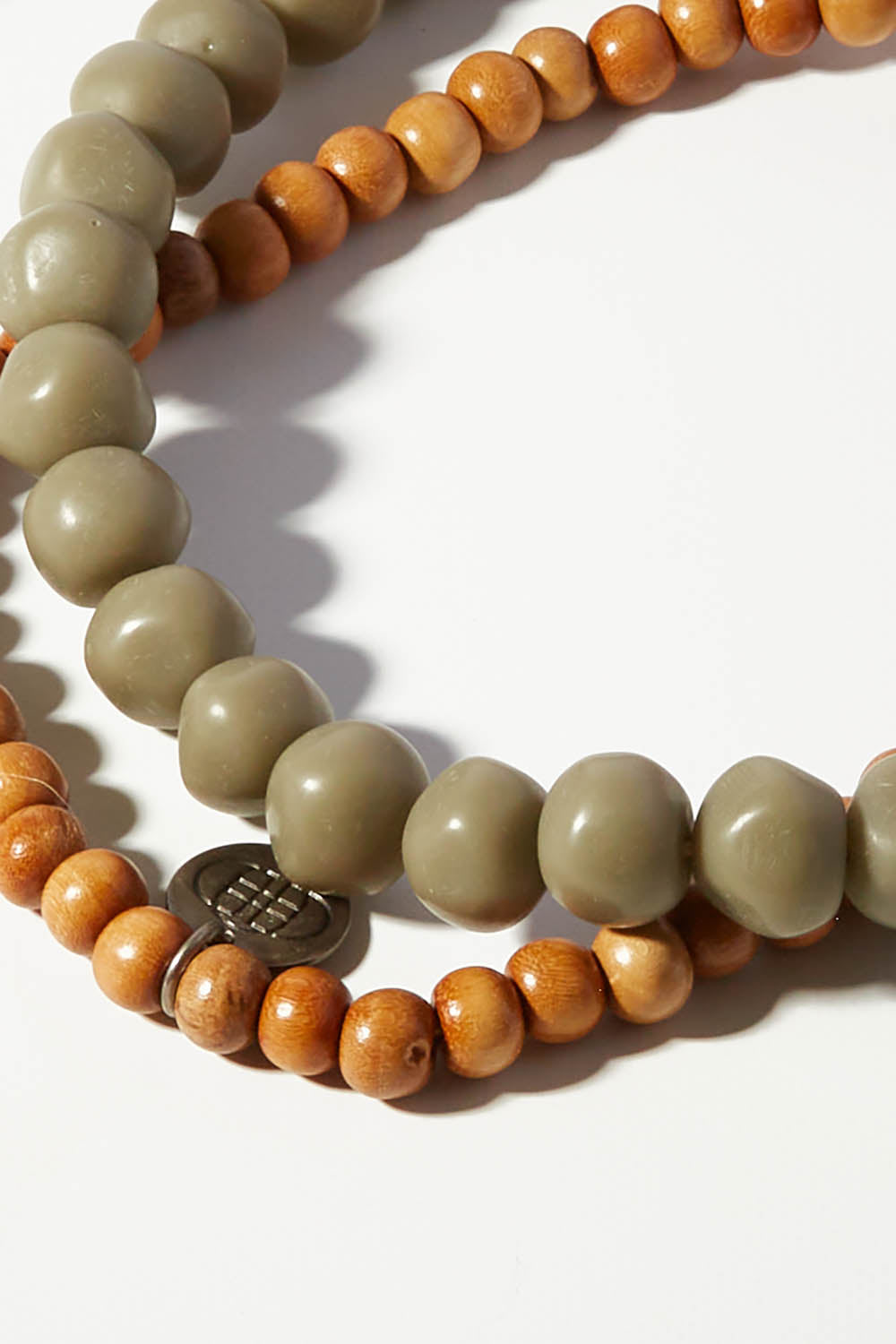 A model wearing size OneSize of the Mini Wood & Rock Necklace in colour Moss (Green), from the front, showing the whole outfit