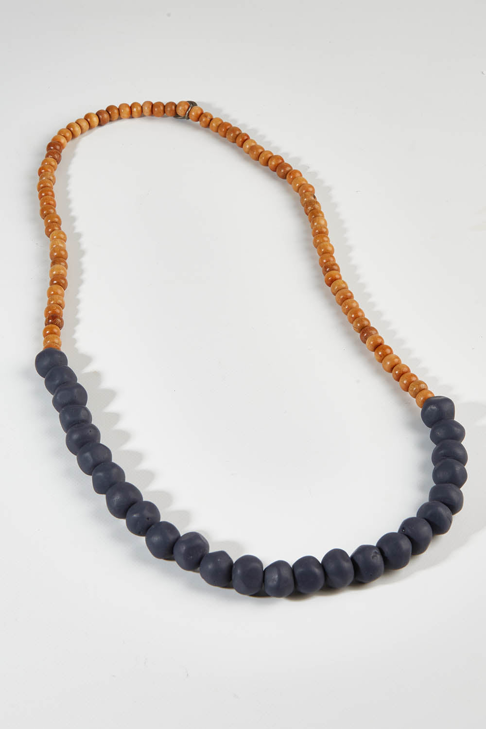 A model wearing size OneSize of the Mini Wood & Rock Necklace in colour Navy (Blue), from the front, showing the whole outfit