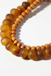 A model wearing size OneSize of the Mini Wood & Rock Necklace in colour Tortoise, from the front, showing the whole outfit