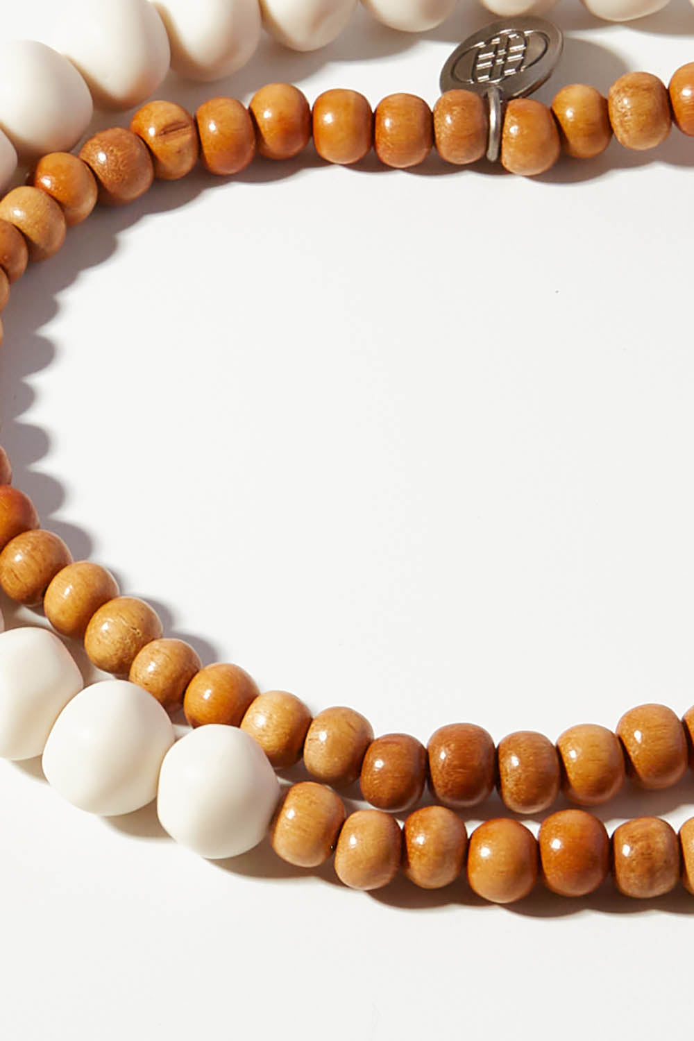 A model wearing the Mini Wood & Rock Necklace in colour White (White), from the front, showing the whole outfit