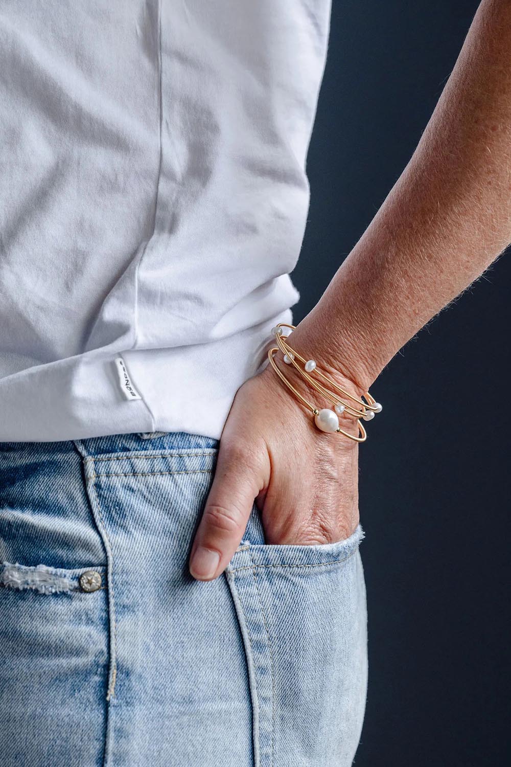 A model wearing the Freshwater Multi Pearl Gold Cuff in colour Goldpearl (Metallics), from the front, cropped image