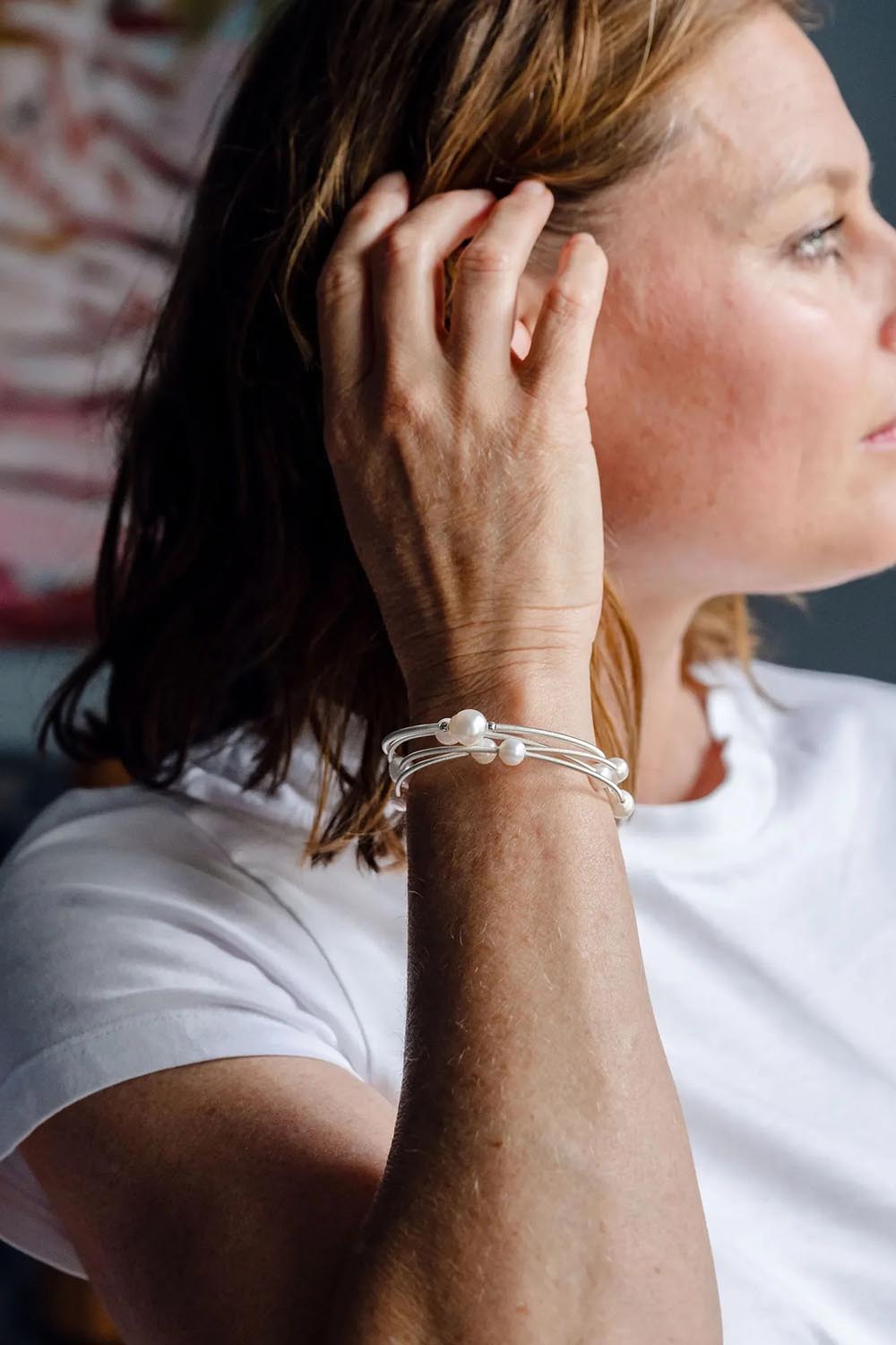 A model wearing the Freshwater Multi Pearl Gold Cuff in colour Silvepearl (Metallics), from the front, cropped image