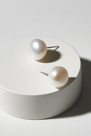 A model wearing size OneSize of the Sterling Silver Medium Pearl Stud in colour Silver (White), from the front, showing the whole outfit