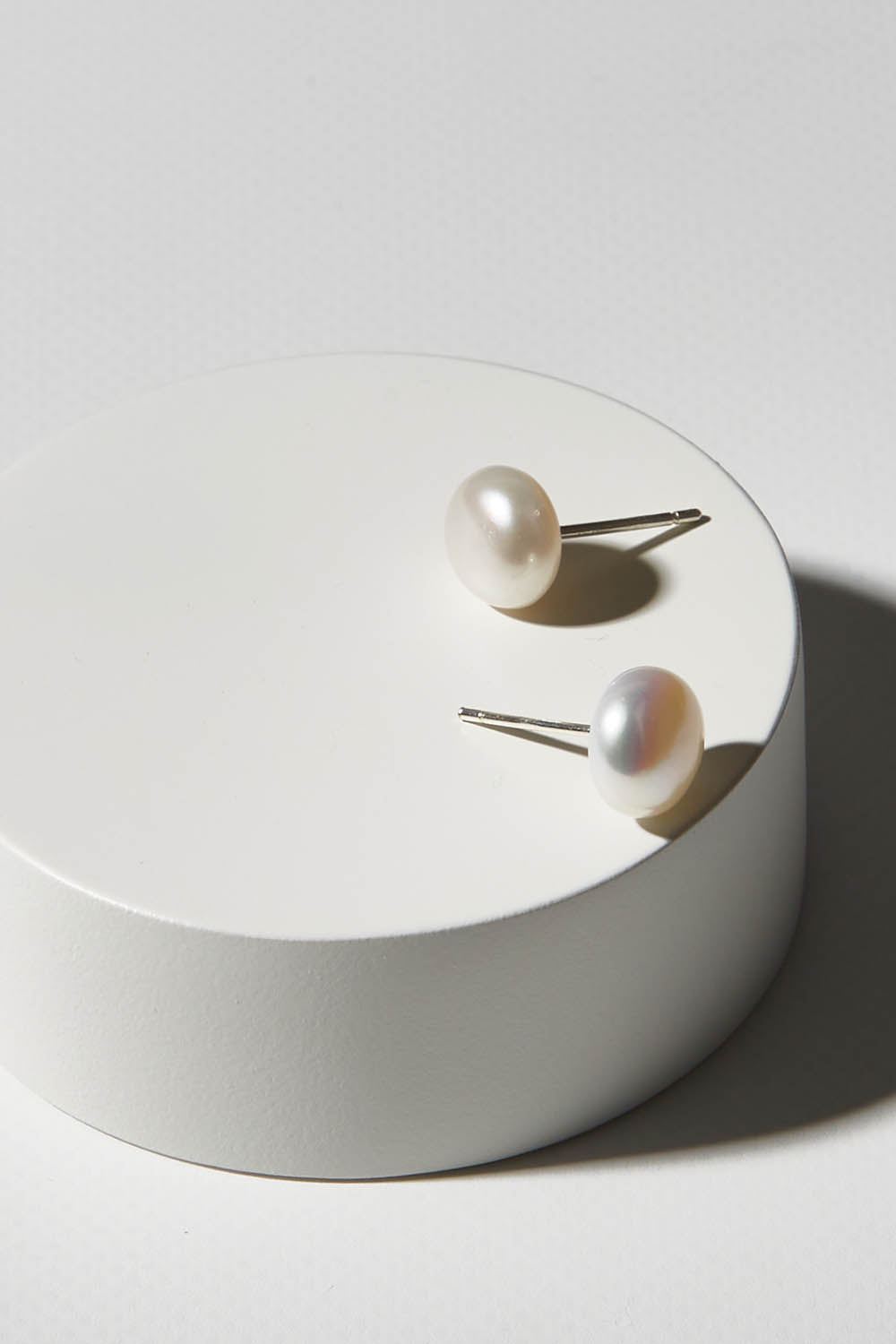 A model wearing size OneSize of the Sterling Silver Small Pearl Stud in colour Silver (White), from the front, showing the whole outfit