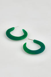 A model wearing the Point Finish Resin Hoop Earring in colour Green (Green), from the front, showing the whole outfit