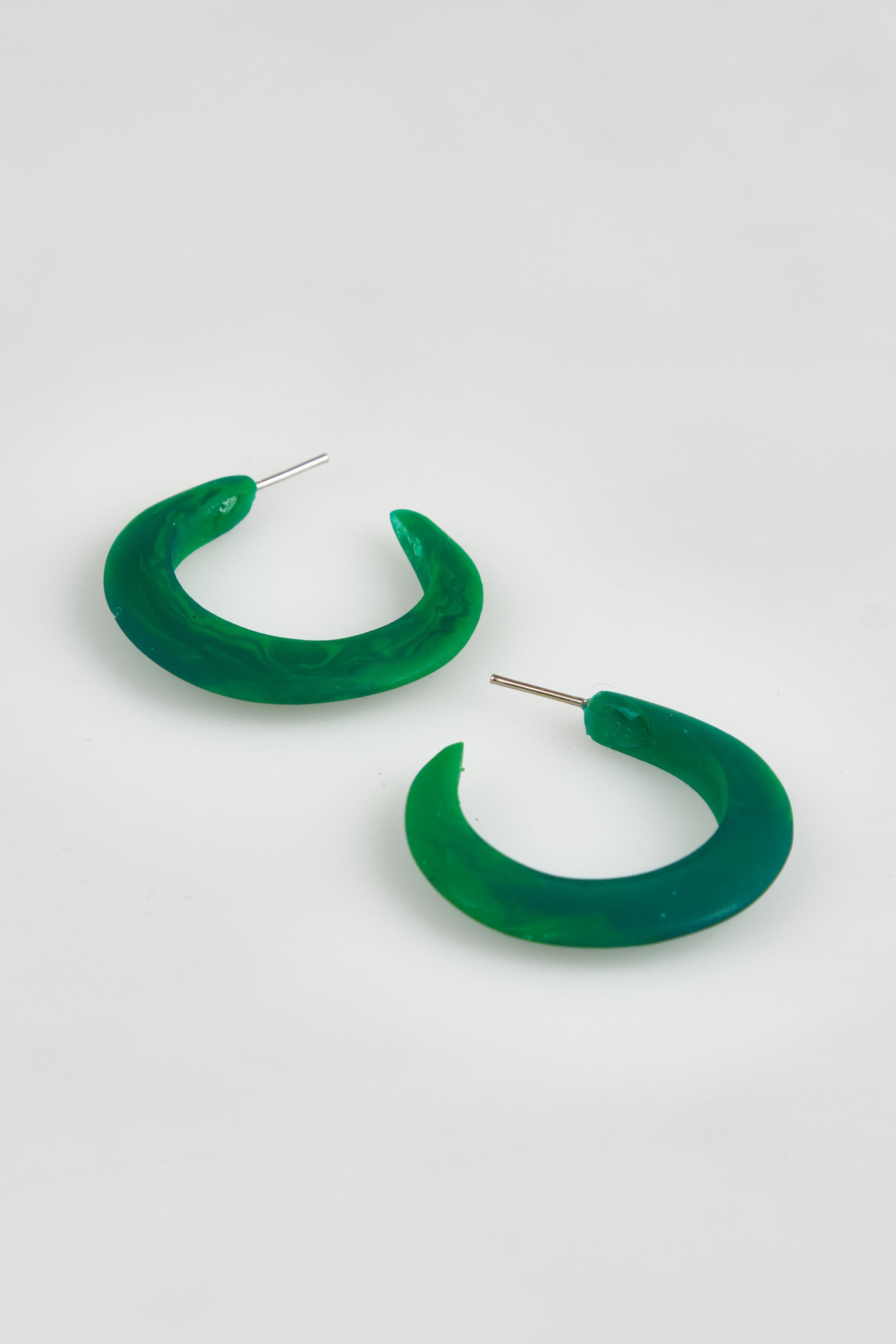 A model wearing the Point Finish Resin Hoop Earring in colour Green (Green), from the front, showing the whole outfit