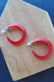 A model wearing the Point Finish Resin Hoop Earring in colour Red (Red), from the front, showing the whole outfit
