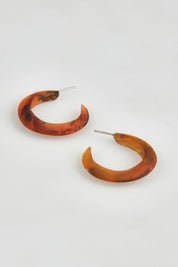 A model wearing the Point Finish Resin Hoop Earring in colour Tortoise, from the front, showing the whole outfit
