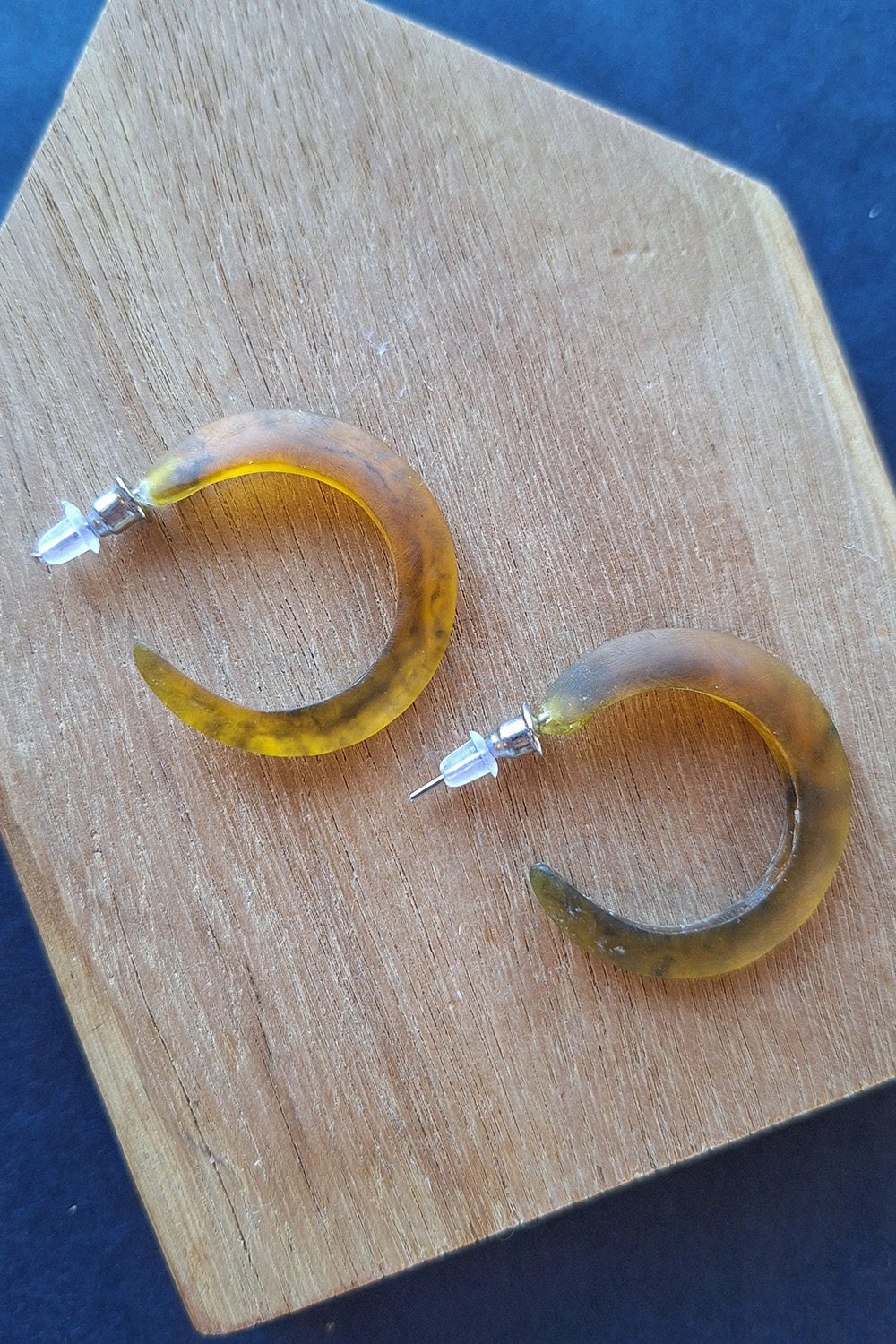 A model wearing the Point Finish Resin Hoop Earring in colour Tortoise, from the front, showing the whole outfit