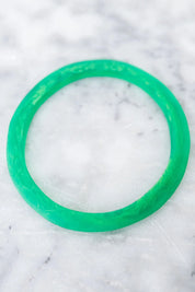 A model wearing the Point Resin Stacking Bangle in colour Green (Green), from the front, showing the whole outfit