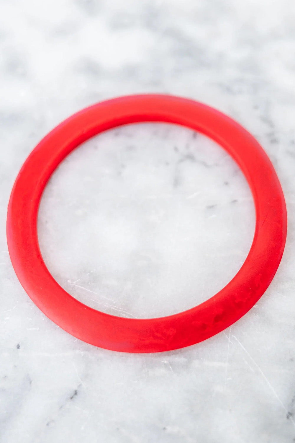 A model wearing the Point Resin Stacking Bangle in colour Red (Red), from the front, showing the whole outfit