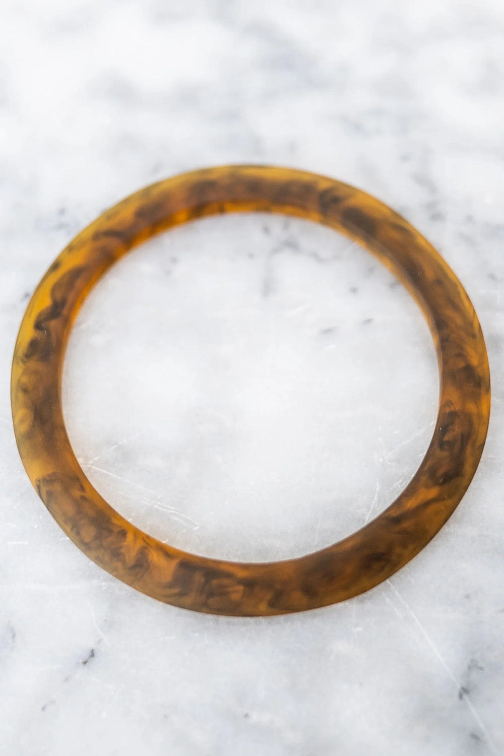 A model wearing the Point Resin Stacking Bangle in colour Tortoise, from the front, showing the whole outfit