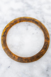 A model wearing the Point Resin Stacking Bangle in colour Tortoise, from the front, showing the whole outfit