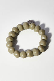 A model wearing size OneSize of the Rock Resin Bracelet in colour Moss (Green), from the front, showing the whole outfit