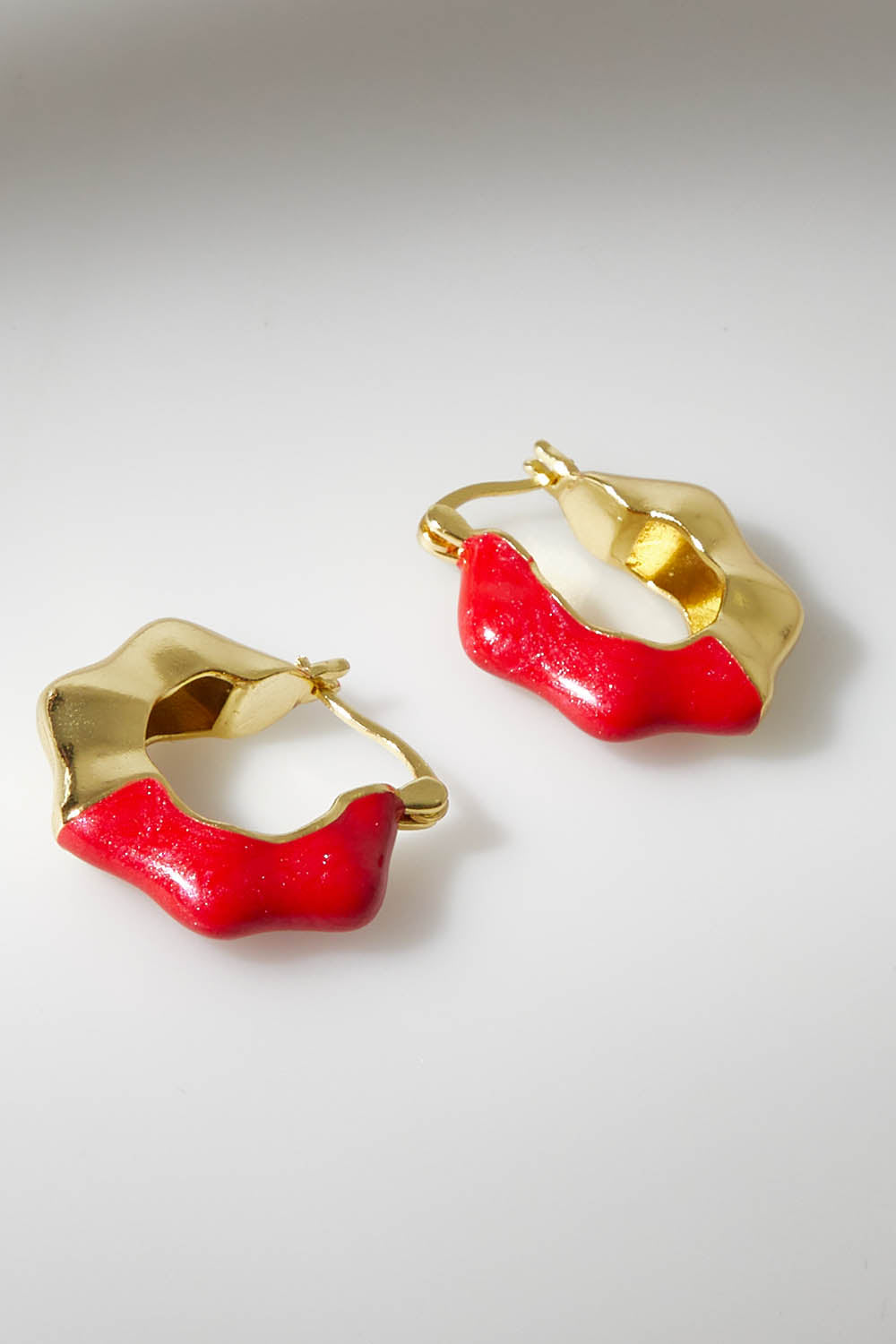 A model wearing size OneSize of the Hoop Earrings in colour Raspberry (Red), from the front, showing the whole outfit