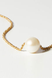 A model wearing size OneSize of the Single Pearl Necklace in colour Gold (Metallics), from the front, showing the whole outfit