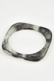 A model wearing the Square Resin Stacking Bangle in colour Black (Black), from the front, showing the whole outfit